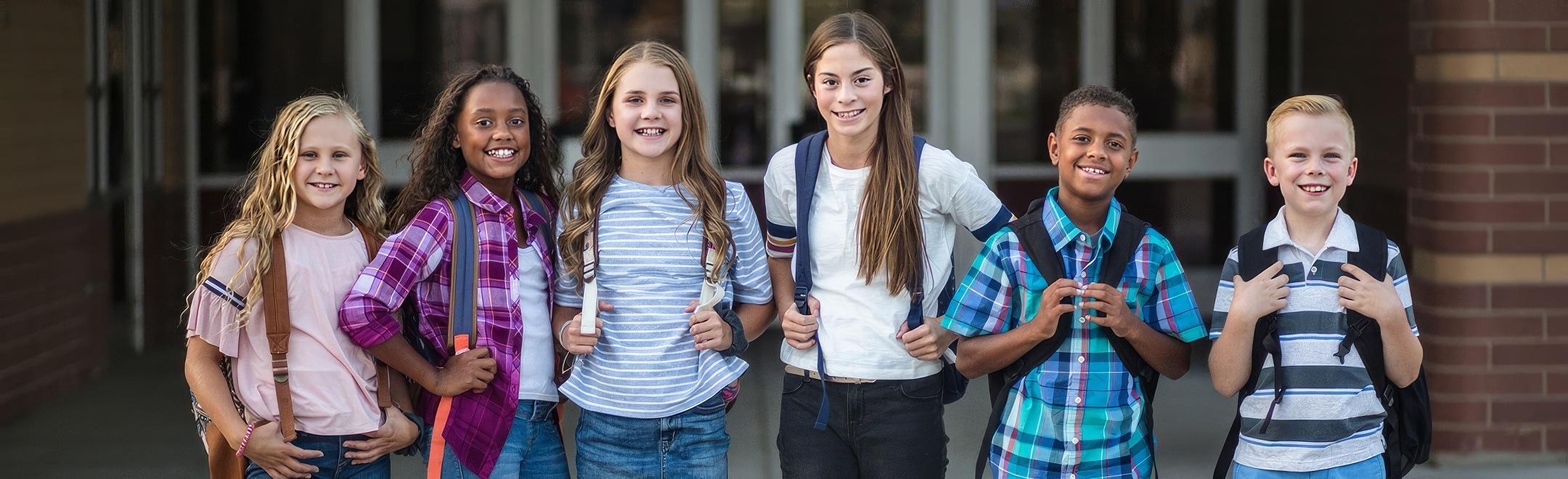 A group of children at school standing up and supporting each other against bullying.