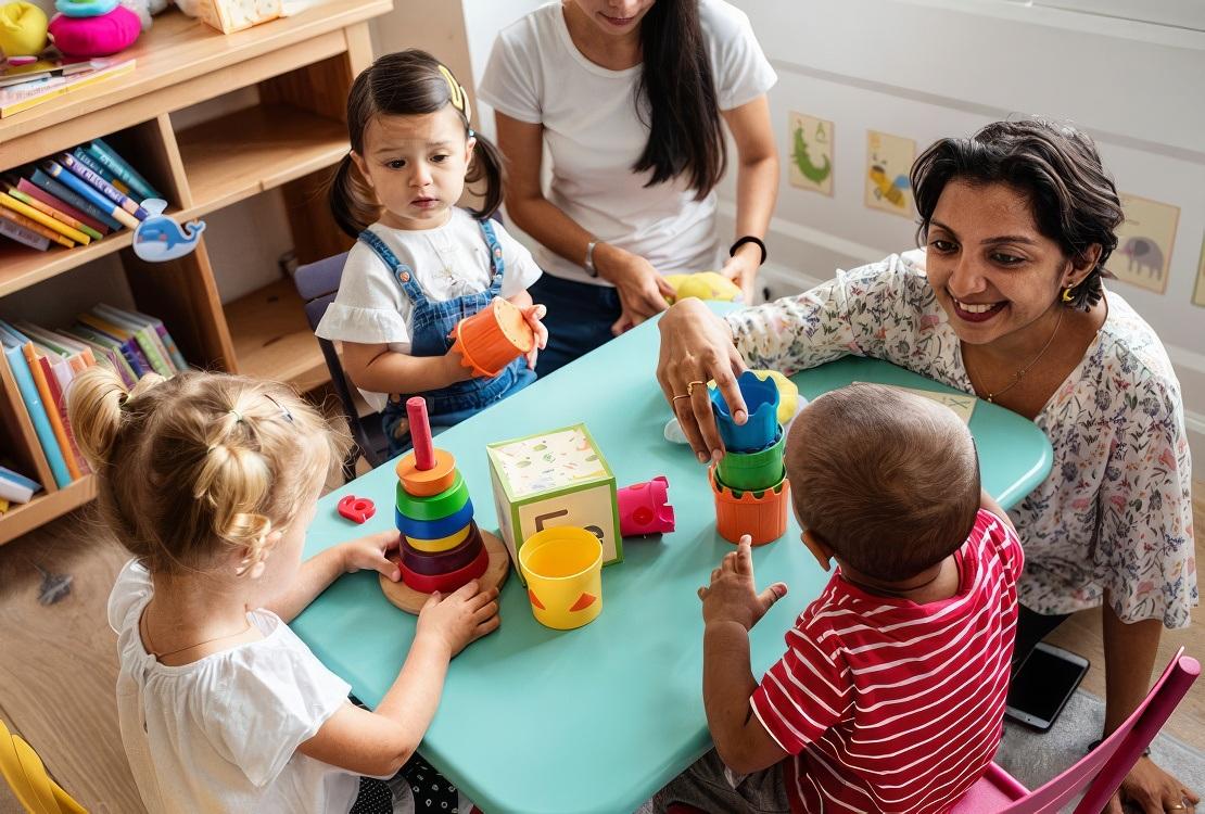 Children in class with teachers observing developmental milestones