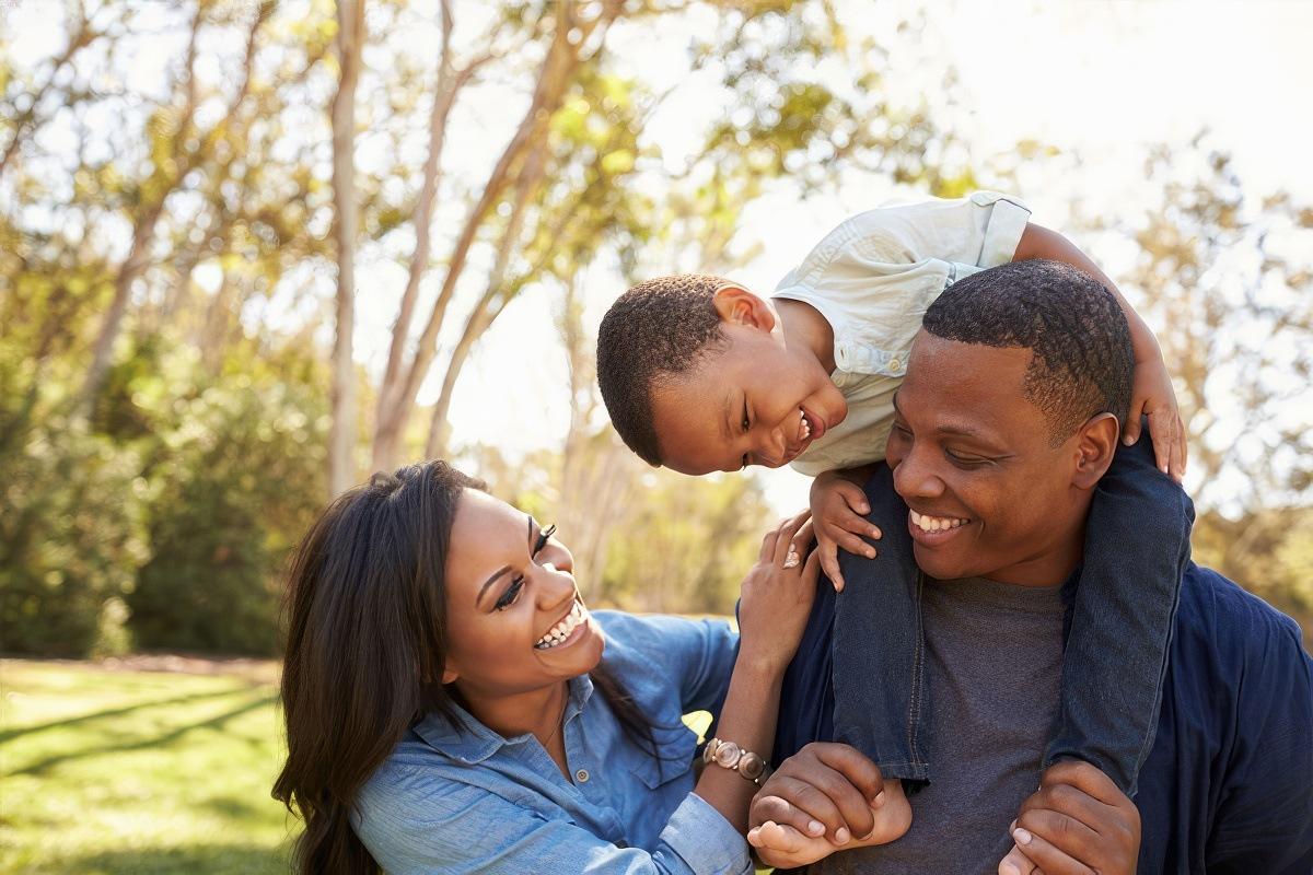 Family Programs: Family with son on dad's shoulders.