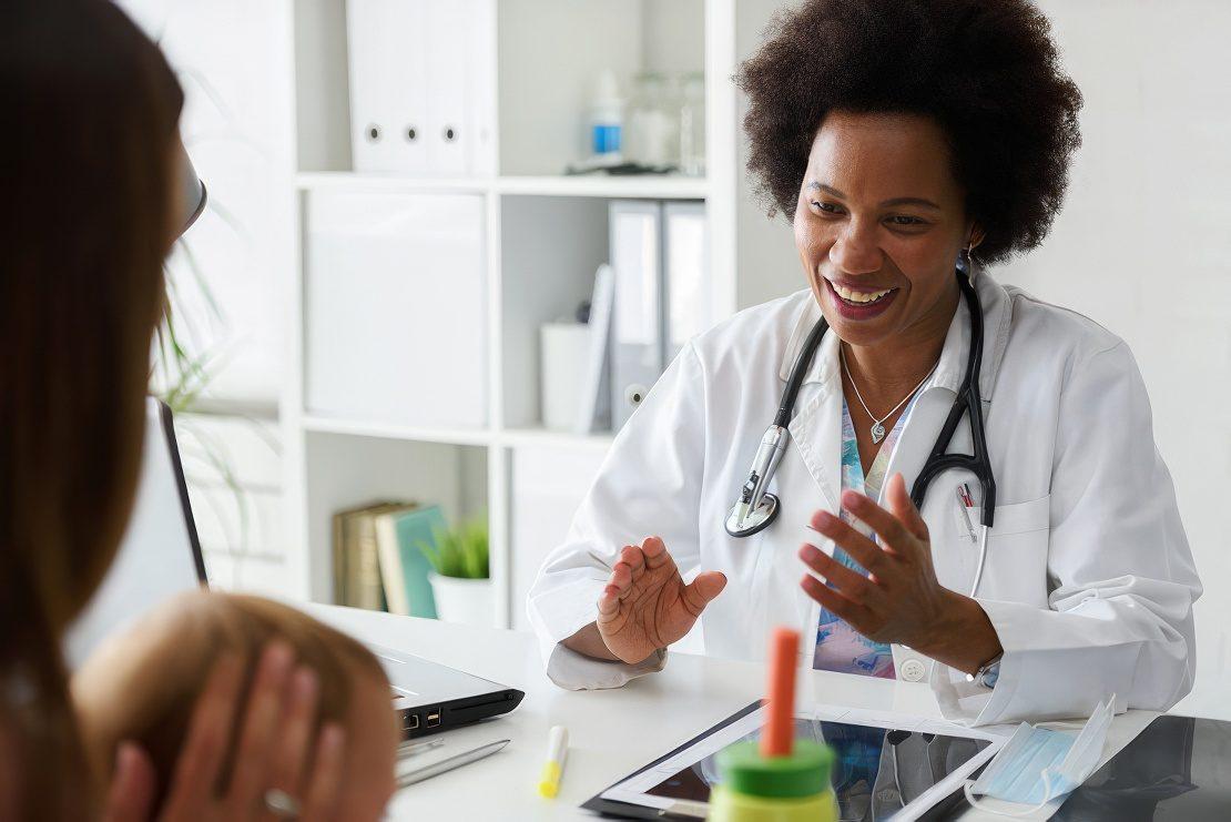 Female doctor speaking with patients, mom and baby