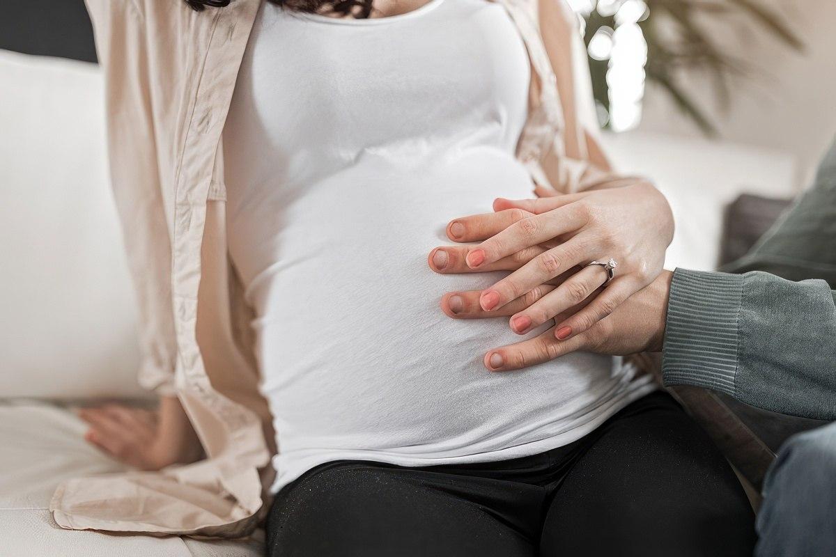 Husband rubbing wife's belly counting their baby's kicks