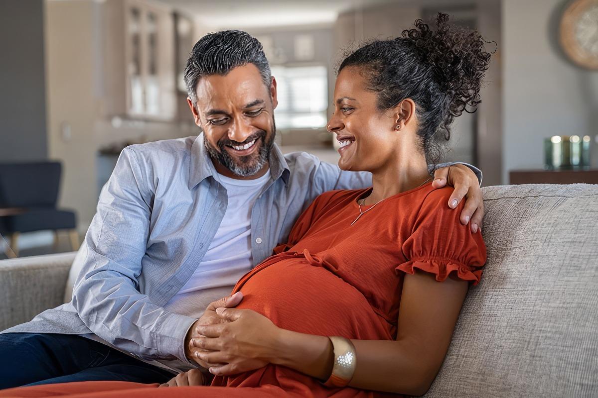 Man touching pregnant woman's belly to feel the baby's kick count