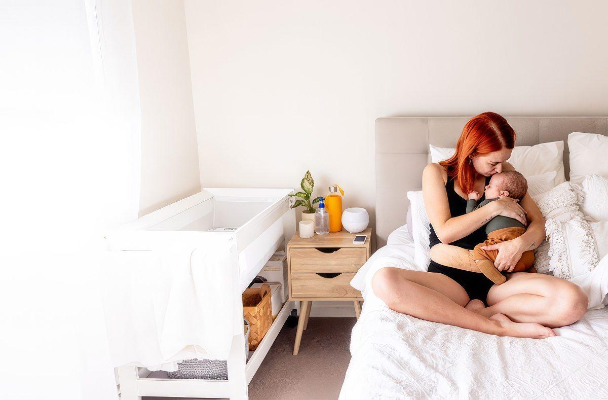 Mom sitting in bed holding her baby