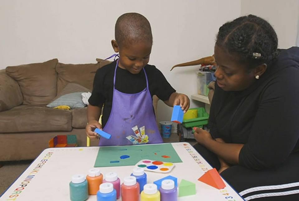 A child age 0-3 and his mom playing with arts and crafts inside.