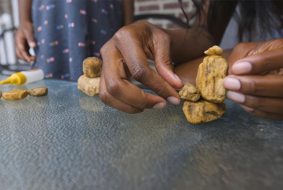 A child age 4-8 and her mom playing with arts and crafts inside.