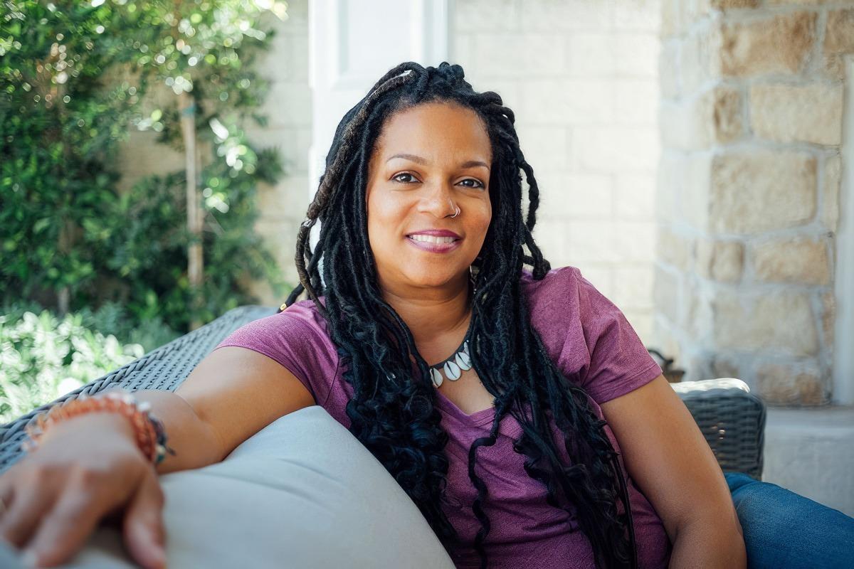 A community health worker sitting on a couch ready to talk.