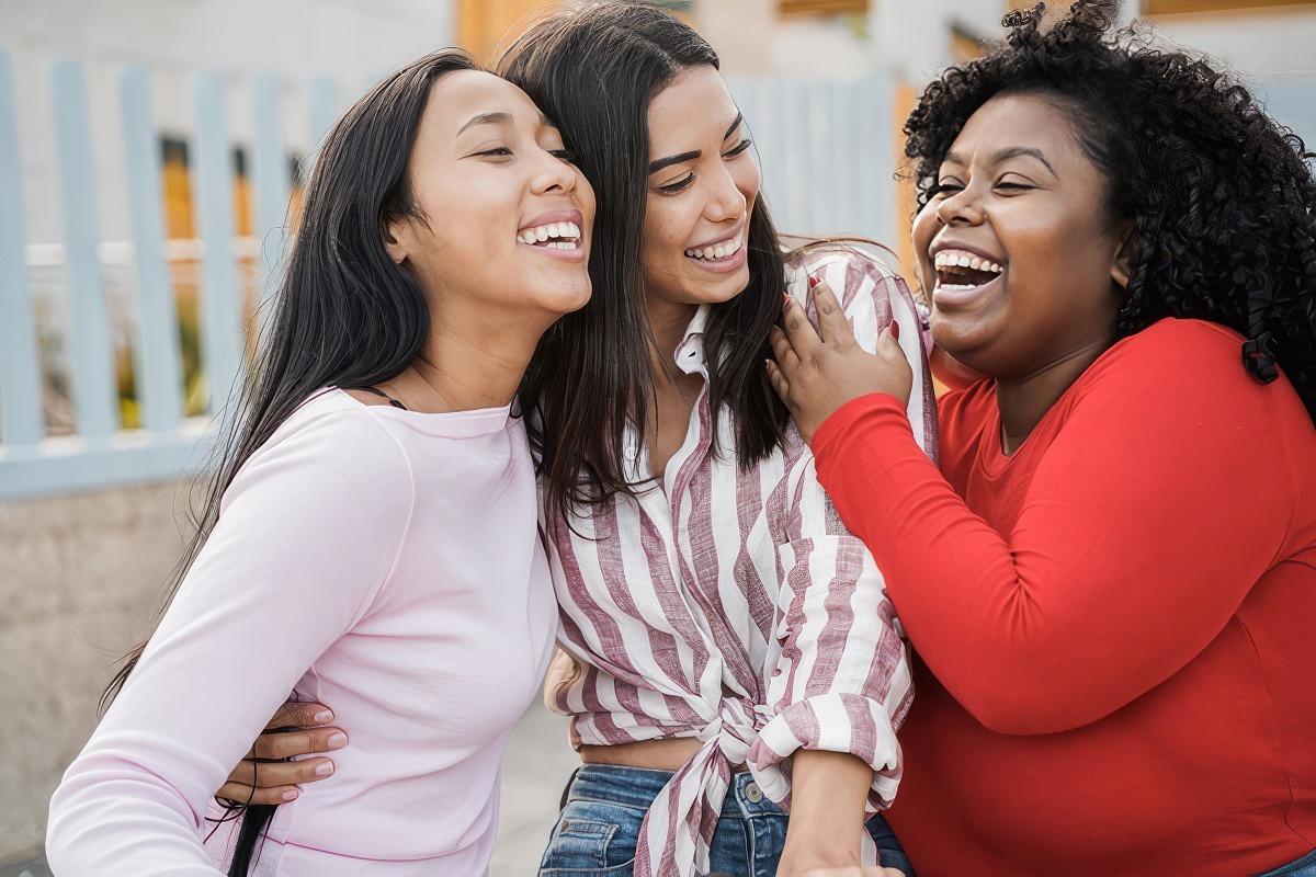 Three healthy Delaware women with their arms around each other and laughing