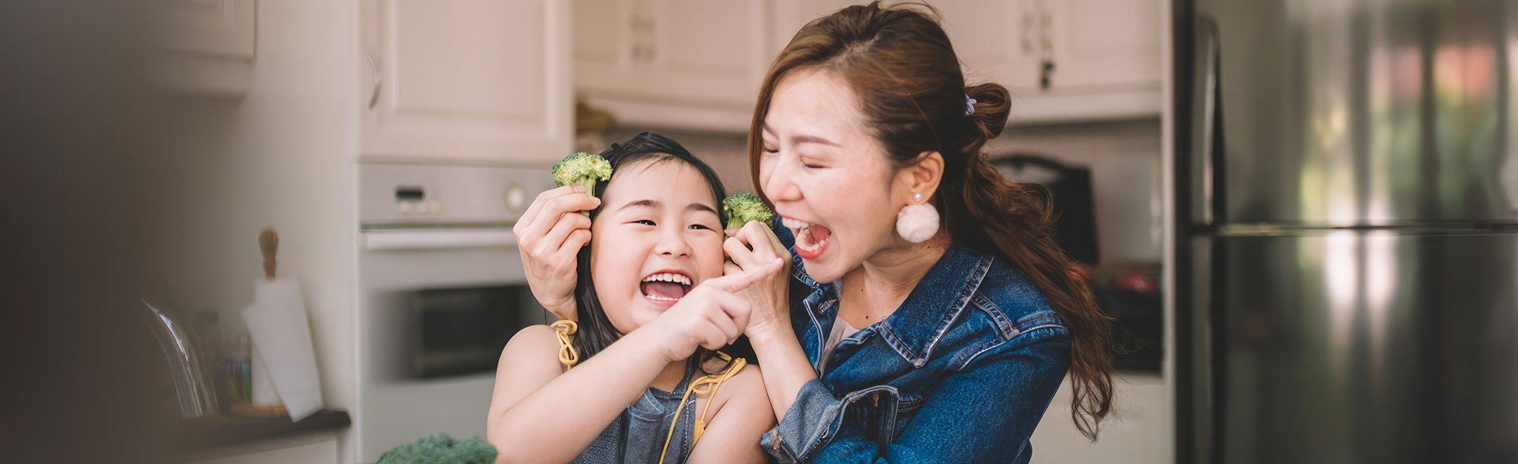 A healthy mom and daughter playing with food