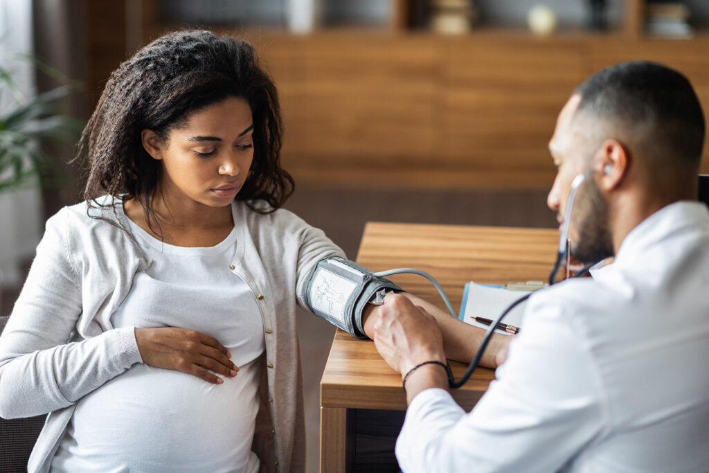 Health care professional checking blood pressure for pregnant woman