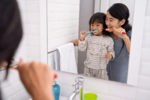 Mother and daughter brushing teeth in the bathroom